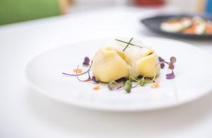 a piece of food on a white plate on a table at Somewhere - Estoril Guesthouse in Estoril