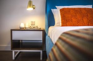 a bedroom with a bed and a night stand with glasses on it at Somewhere - Estoril Guesthouse in Estoril