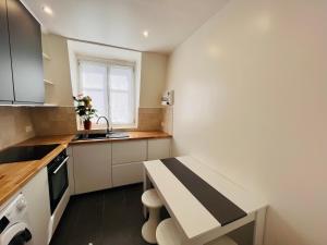 a small kitchen with a counter and a sink at Appartement neuf, au calme, proche métro in Boulogne-Billancourt