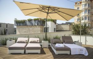 a patio with two beds and an umbrella at Somewhere - Estoril Guesthouse in Estoril