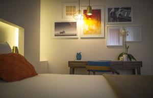 a bedroom with a bed and a desk and a table at Somewhere - Estoril Guesthouse in Estoril