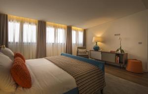 a hotel room with a bed and a chair and window at Somewhere - Estoril Guesthouse in Estoril