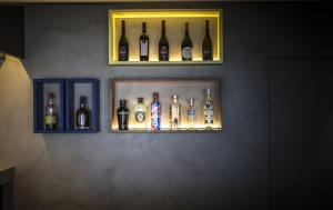 a shelf with bottles of alcohol on a wall at Somewhere - Estoril Guesthouse in Estoril
