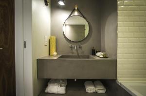 a bathroom with a sink with a mirror and towels at Somewhere - Estoril Guesthouse in Estoril