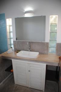 eine Badezimmertheke mit einem Waschbecken und einem Spiegel in der Unterkunft camera matrimoniale grande terrazza vista stupenda in Nosy Be