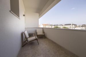 two chairs sitting on a balcony with a view at Somewhere - Estoril Guesthouse in Estoril