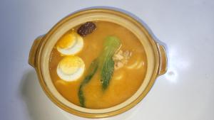 a bowl of soup with eggs and vegetables in it at Kharkhorin hostel in Harhorin