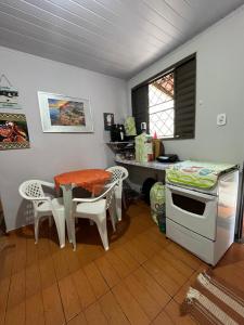 een keuken met een tafel, een tafel en een bureau bij Casa Recanto - Quarto simples in Rio Verde