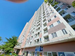 un alto condominio rosa con un cielo blu sullo sfondo di OYO 93366 Apartement Grand Sentraland By Rai Property a Jaken 1