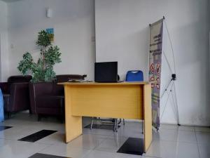 una scrivania in legno in una stanza con sedie di OYO 93366 Apartement Grand Sentraland By Rai Property a Jaken 1