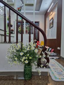 een vaas met bloemen op een tafel in de gang bij May's Cottage in Hanoi