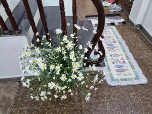 un ramo de flores blancas sentado en el suelo en May's Cottage, en Hanói