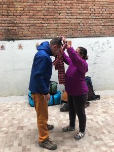 a man and a woman standing next to a brick wall at BnB Royal Tourist House in Kathmandu