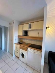 een keuken met een wasmachine en een wasmachine bij Front de mer, 8min du Palais des Festivals in Cannes