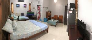1 dormitorio con 1 cama y TV. en Homey Stopover Cherating, en Kuantan