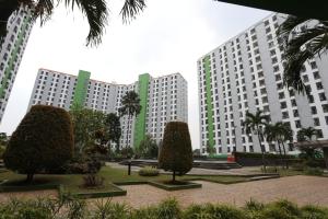 2 grands bâtiments blancs avec des arbres dans un parc dans l'établissement Capital O 93371 Pelangi Residence 5, à Tangerang