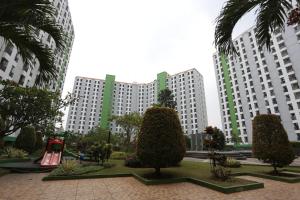 un parc avec des arbres et un toboggan en face de grands bâtiments dans l'établissement Capital O 93371 Pelangi Residence 5, à Tangerang