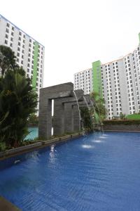 une grande piscine en face de certains bâtiments dans l'établissement Capital O 93371 Pelangi Residence 5, à Tangerang