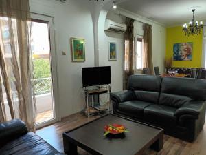 een woonkamer met een bank en een tafel bij Stunning apartment in the heart of Athens in Athene