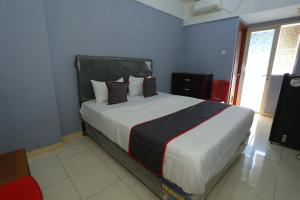 ein Schlafzimmer mit einem großen Bett in einem Zimmer in der Unterkunft Capital O 93372 Aurora Residence in Tangerang