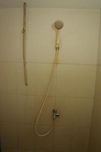 une douche avec un tuyau fixé à un mur dans l'établissement Capital O 93371 Pelangi Residence 5, à Tangerang