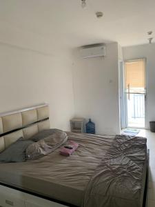 uma cama num quarto branco com uma cama grande em OYO Life 93374 Andira Inn em Depok