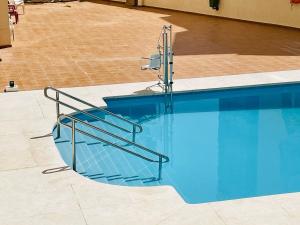 a swimming pool with a metal stair railing next to it at Luxury loft with pool in the centre in Torremolinos