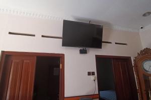 a flat screen tv hanging on a wall at SPOT ON 93376 Roemah Ambarrukma 185 Syariah in Yogyakarta