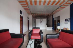 a living room with two couches and a stool at SPOT ON 93378 Lona Guest House Syariah in Parit