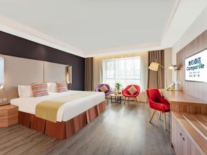 西安市にあるCampanile Hotel Xi'an Dayan Pagoda Datang Night City Hotelのベッドとデスクが備わるホテルルームです。