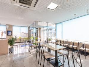 西条市Hotel HORAIRE Saijo的有桌椅和窗户的餐厅