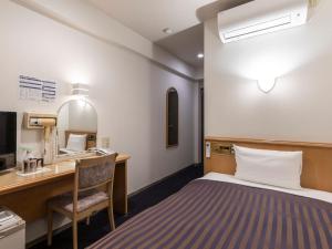 een hotelkamer met een bed en een bureau bij Hotel HORAIRE Saijo in Saijo