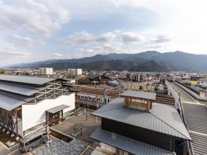 una vista aérea de una estación de tren con montañas en el fondo en Hotel HORAIRE Saijo, en Saijo