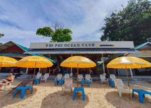 un grupo de sillas y sombrillas en una playa en Phi Phi Ocean Club, en Islas Phi Phi