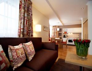 ein Wohnzimmer mit einem Sofa und einem Tisch mit roten Rosen in der Unterkunft Sonnblick Apartments und Zimmer - Nationalpark Sommercard inklusive in Hollersbach im Pinzgau