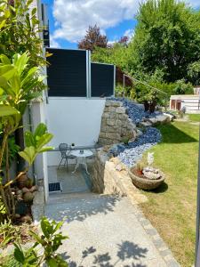 a garden with a stone wall and a patio at 1,5 Zimmer Apartment in S-Bahn Nähe, 35 qm, max 4 Pers, zentral, private Terasse, Internet 250 MBit in Gärtringen