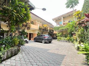 un coche aparcado en un aparcamiento al lado de un edificio en SPOT ON 93398 Sudimoro Guest House Syariah, en Blimbing