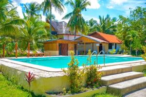 une villa avec une piscine en face d'une maison dans l'établissement Native House Resort by Cocotel, à Moalboal