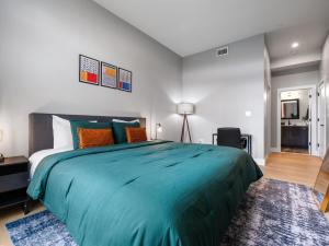 a bedroom with a large bed with a blue comforter at Stunning 2BR Condo in Assembly Square East Somerville in Somerville