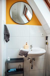 ein Bad mit einem Waschbecken und einem Spiegel in der Unterkunft Central-Living yellow - Wifi - Netflix - City in Essen