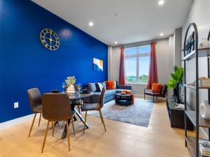 a living room with blue walls and a table and chairs at Stunning 2BR Condo in Assembly Square East Somerville in Somerville