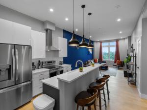 une cuisine avec des placards blancs et un mur bleu dans l'établissement Stunning 2BR Condo in Assembly Square East Somerville, à Somerville