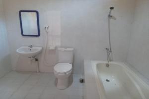 a bathroom with a toilet and a sink and a tub at Capital O 93391 Golden Manggis Hotel in Narmada