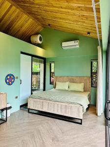 a bedroom with a large bed in a green wall at Anna Little Garden - Homestay Sóc Sơn - Thong House in Hanoi