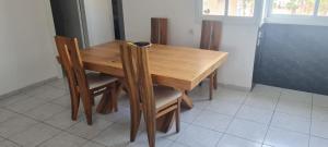 uma mesa de madeira e cadeiras numa cozinha em Светлая и уютная квартира у моря em Haifa