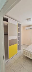 1 dormitorio con armario y puerta amarilla en Светлая и уютная квартира у моря en Haifa
