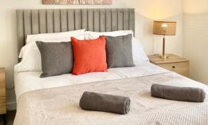 sypialnia z dużym białym łóżkiem z kolorowymi poduszkami w obiekcie Ashford Penthouse Apartment near town with free parking, linens & towels great for contractors or families w mieście Ashford