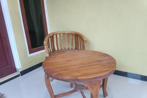 uma mesa de madeira e cadeira num quarto em OYO 93408 Penginapan Annisya em Mataram