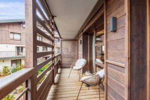 a wooden balcony with two chairs on a building at Apartment with relaxation area in Megève - Welkeys in Megève