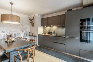 a kitchen and dining room with a table and chairs at Apartment with relaxation area in Megève - Welkeys in Megève